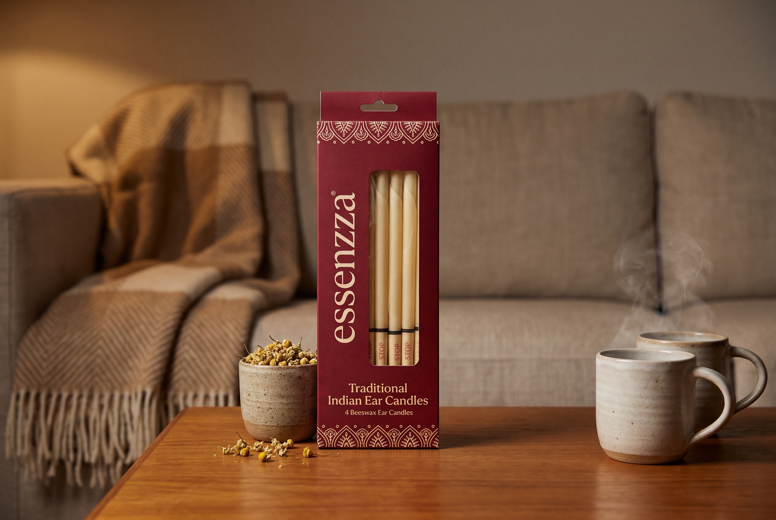 Essenzza Traditional Indian ear candles pack still-life — crimson carton with honey sage and camomile on a warm-timber side table