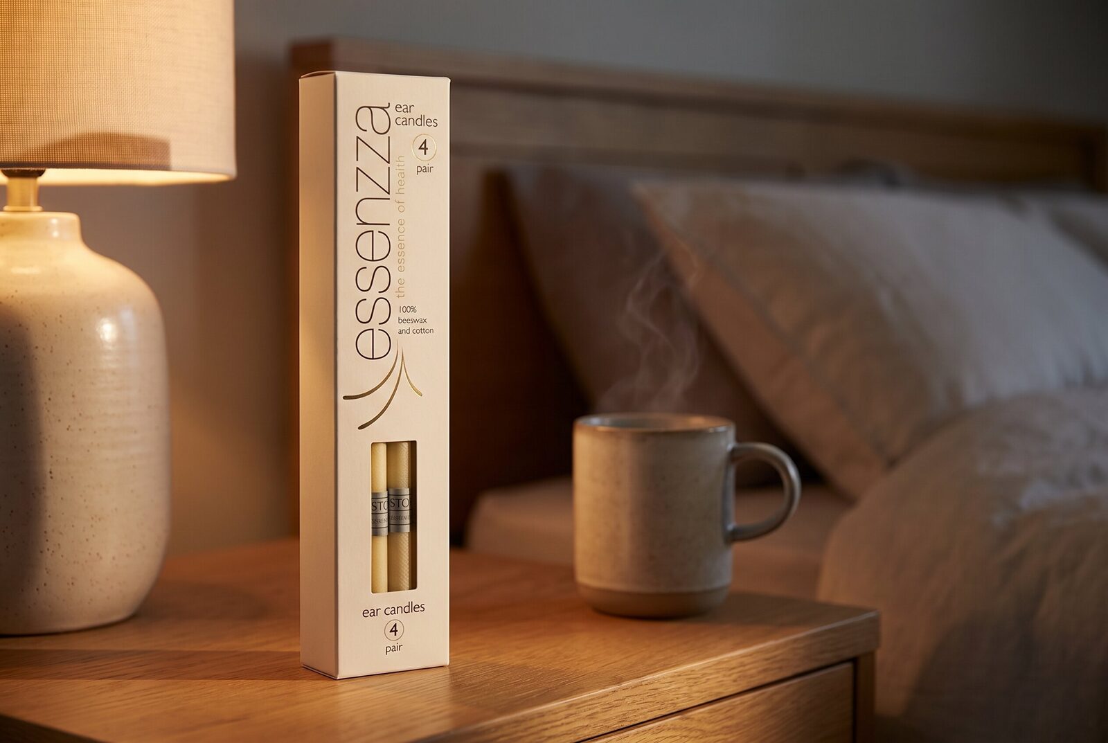Essenzza Original ear candles pack still-life — cream carton beside a warm ceramic lamp at dusk